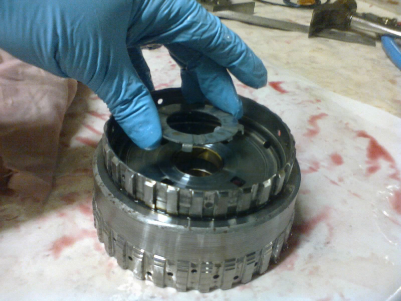 Now for the front sun gear assembly and its thrust washer. The lower teeth here engage the 2-4 clutch frictions. The upper teeth will connect to the input drum. And underneath, the’s a sun gear that meshes with the front planetary.